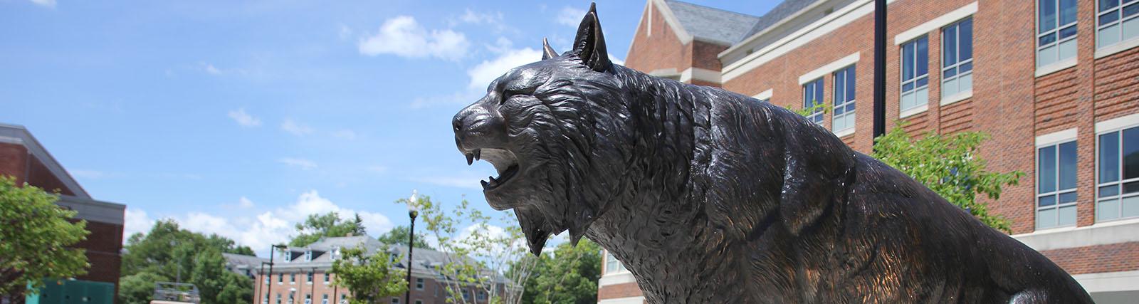 Bobcat statue in front of Compton Science Center with bright blue sky in background