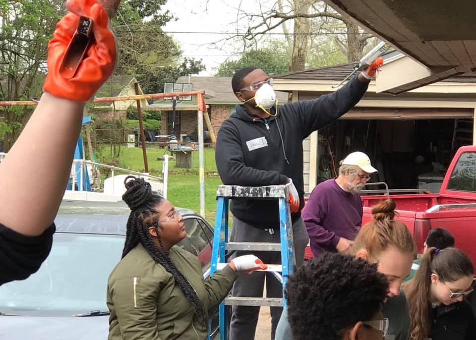 student volunteers repairing a house